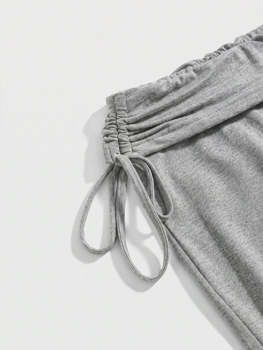 Women's low waist flare leg pants featuring an elastic drawstring waistband and ruched detail in knitted fabric.
