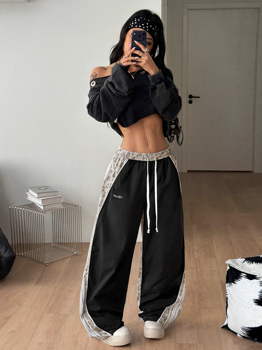 Women's loose fit straight leg pants in black and white with banded texture design, low drawstring waist, and pockets.
