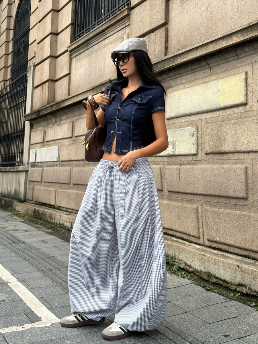Women's loose-fit black bloomer pants made of 100% cotton featuring an elastic waistband and side pockets.