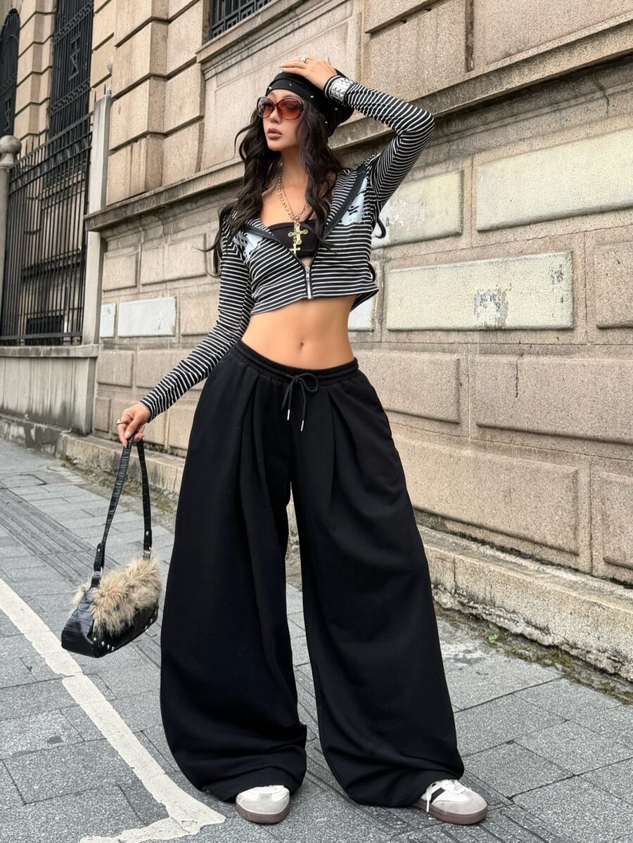 Women's casual black loose fit baggy banana pants featuring a low rise elastic drawstring waist and side pockets.