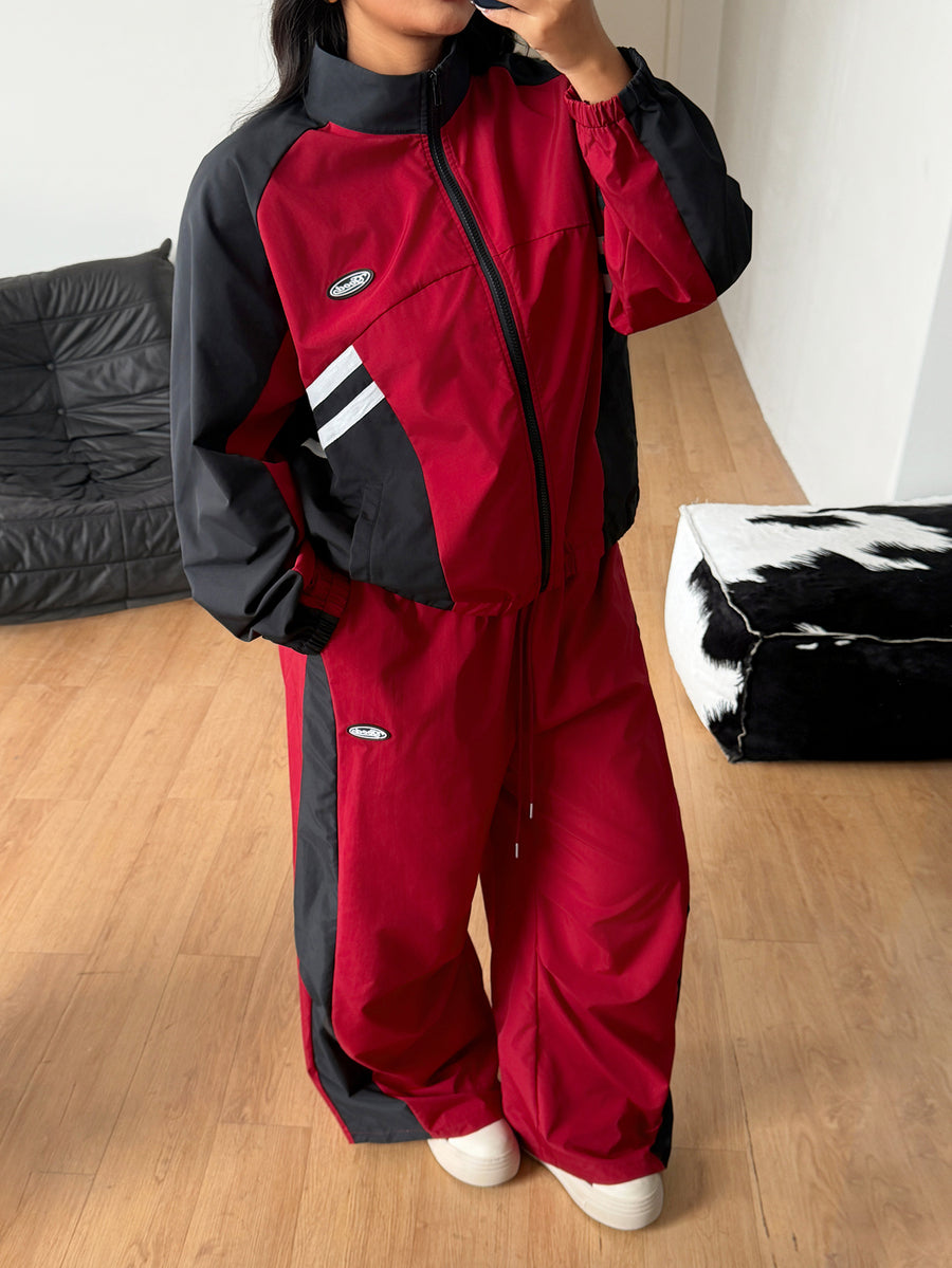 Women's plus size two-piece casual tracksuit set in black, featuring a loose-fit zip-up jacket with stand collar and matching cropped parachute pants.