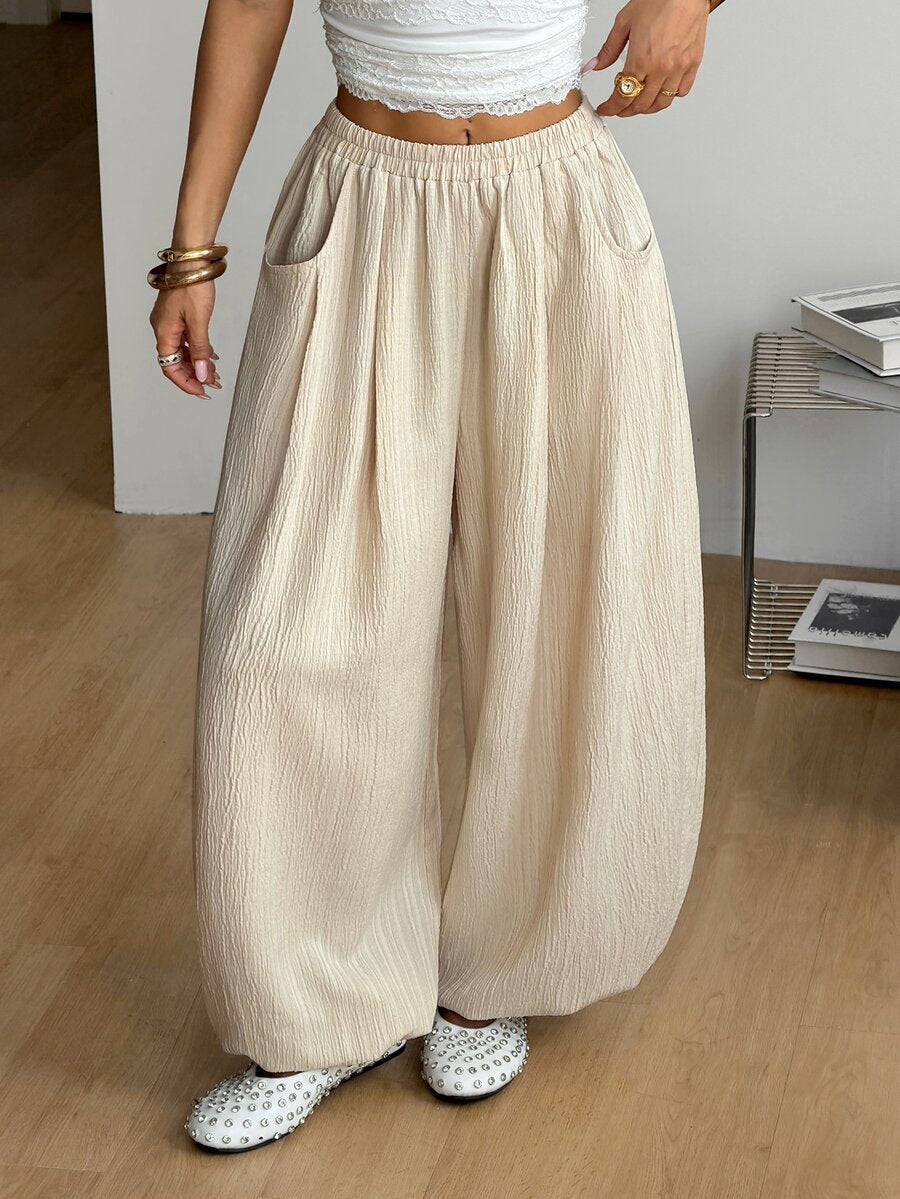 Women's loose-fit black bloomer pants made of 100% cotton featuring an elastic waistband and side pockets.