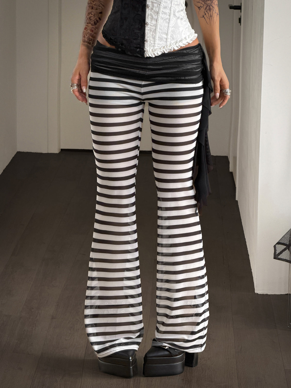 Women's black and white polka dot flare leg pants with side drawstring and ruched details