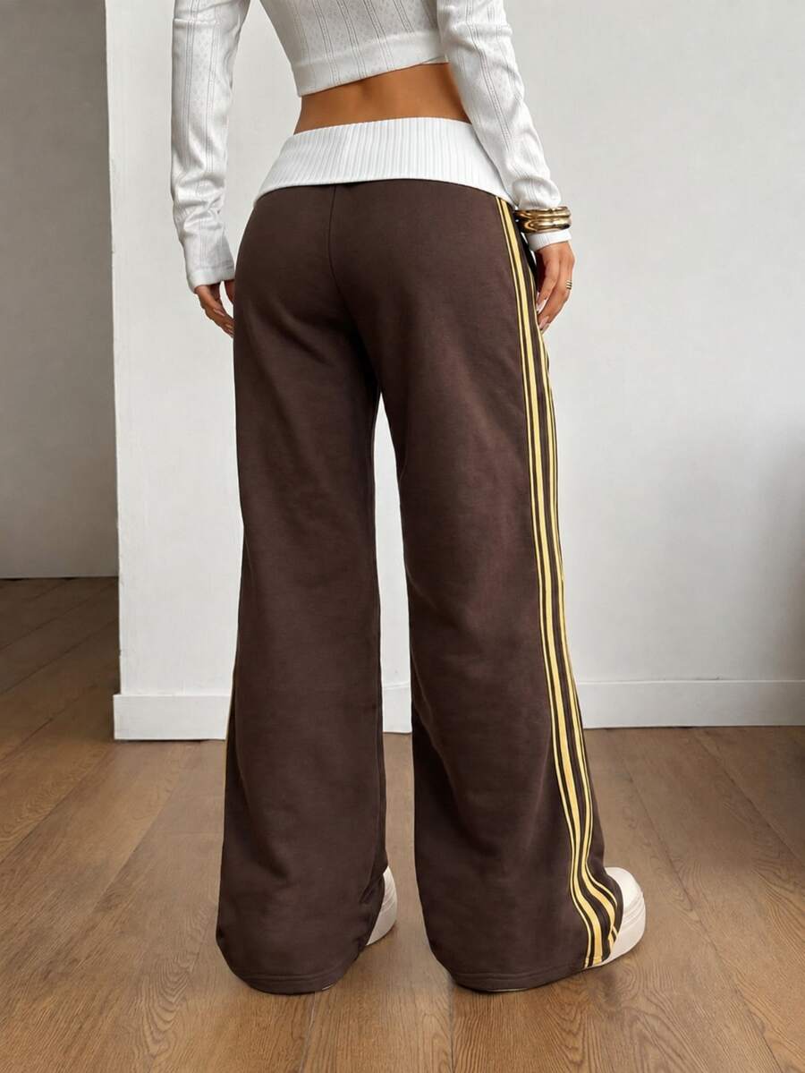 Women's wide leg flare sweatpants featuring a black and white colorblock contrast fold waistband and side stripe details.