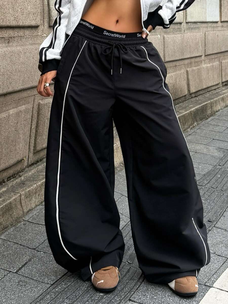 Women's loose fit straight leg pants in black and white with banded texture design, low drawstring waist, and pockets.