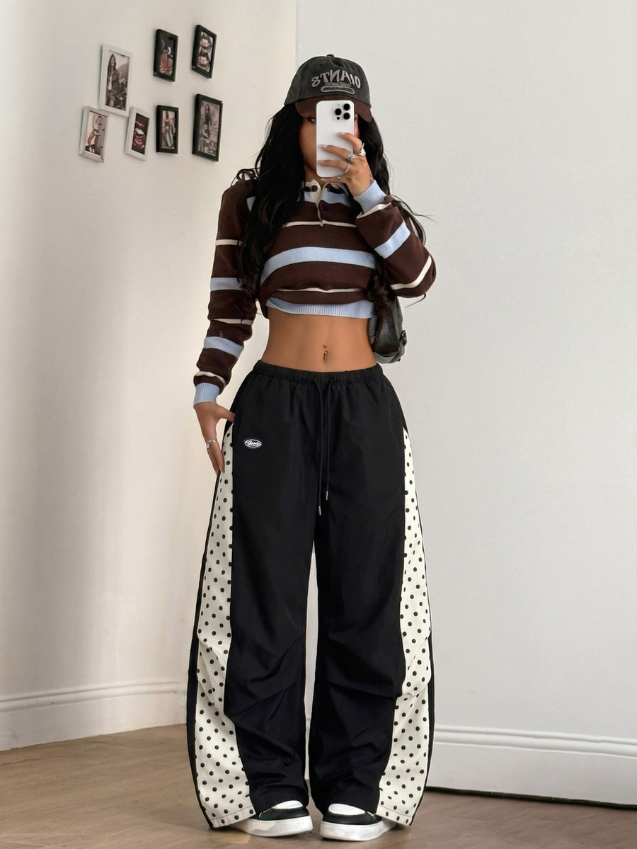 Women's black baggy jogger pants with an adjustable drawstring waist and colorblock polka dot geometric pattern.