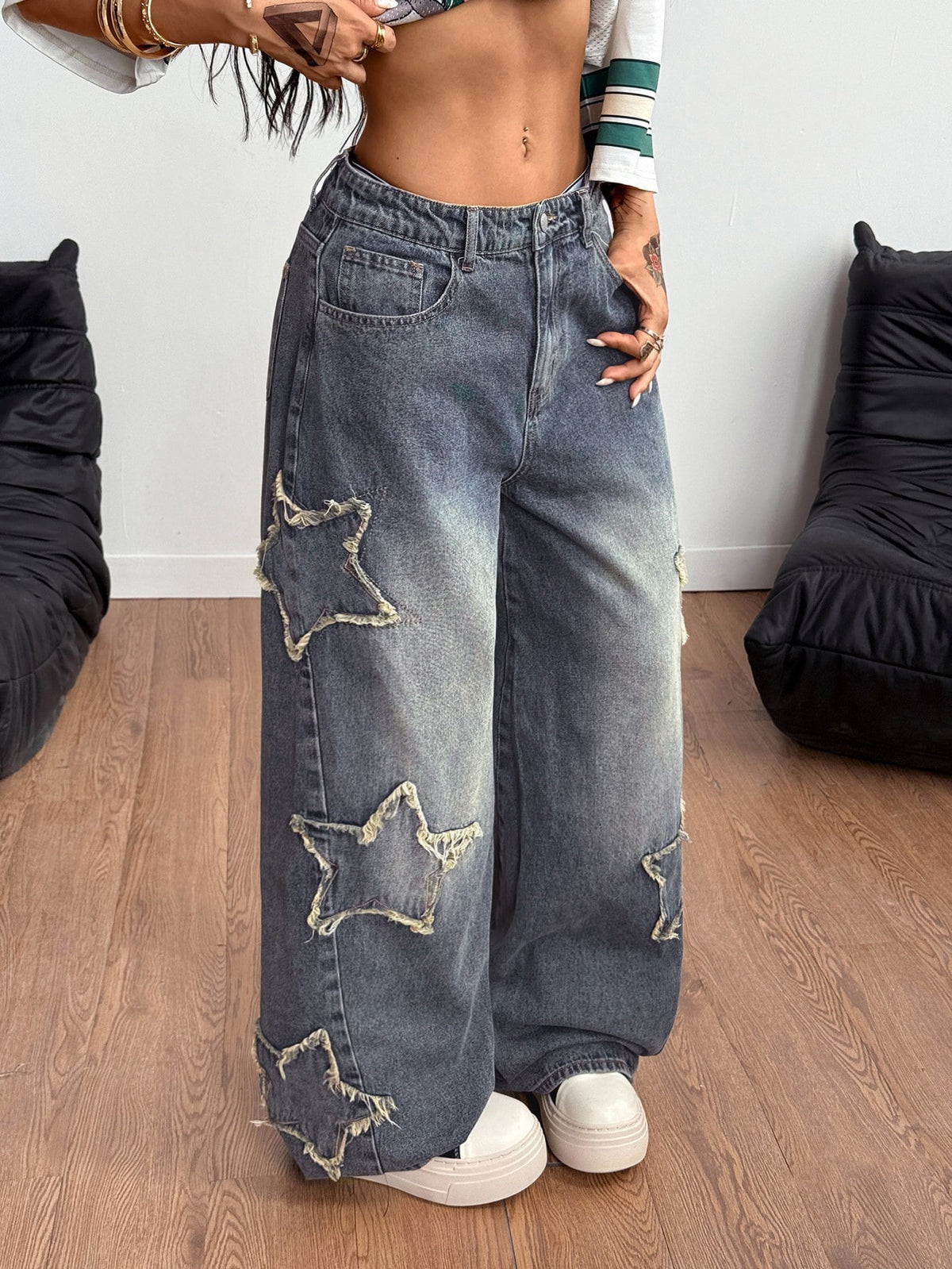 Women's loose fit baggy jeans in washed denim featuring star patches, slant pockets, and a mid-rise cut.