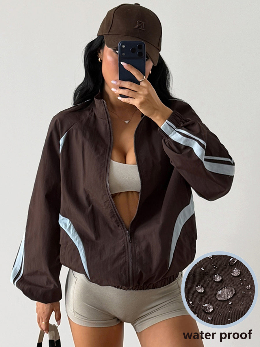 Front view of a women's oversized coffee brown sports jacket featuring a high neckline, front zipper closure, and long sleeves.