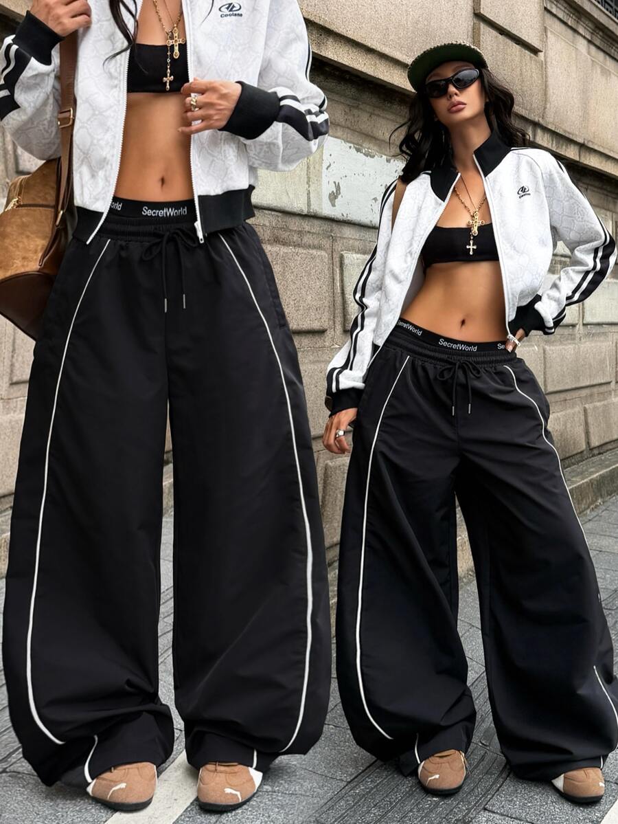 Women's loose fit straight leg pants in black and white with banded texture design, low drawstring waist, and pockets.