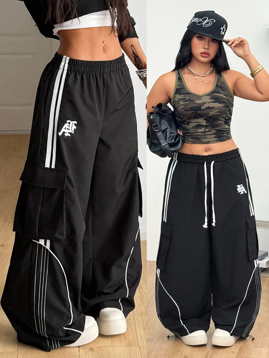 Women's plus size loose straight leg pants featuring a black and white color block design with side stripes and an elastic drawstring waist.