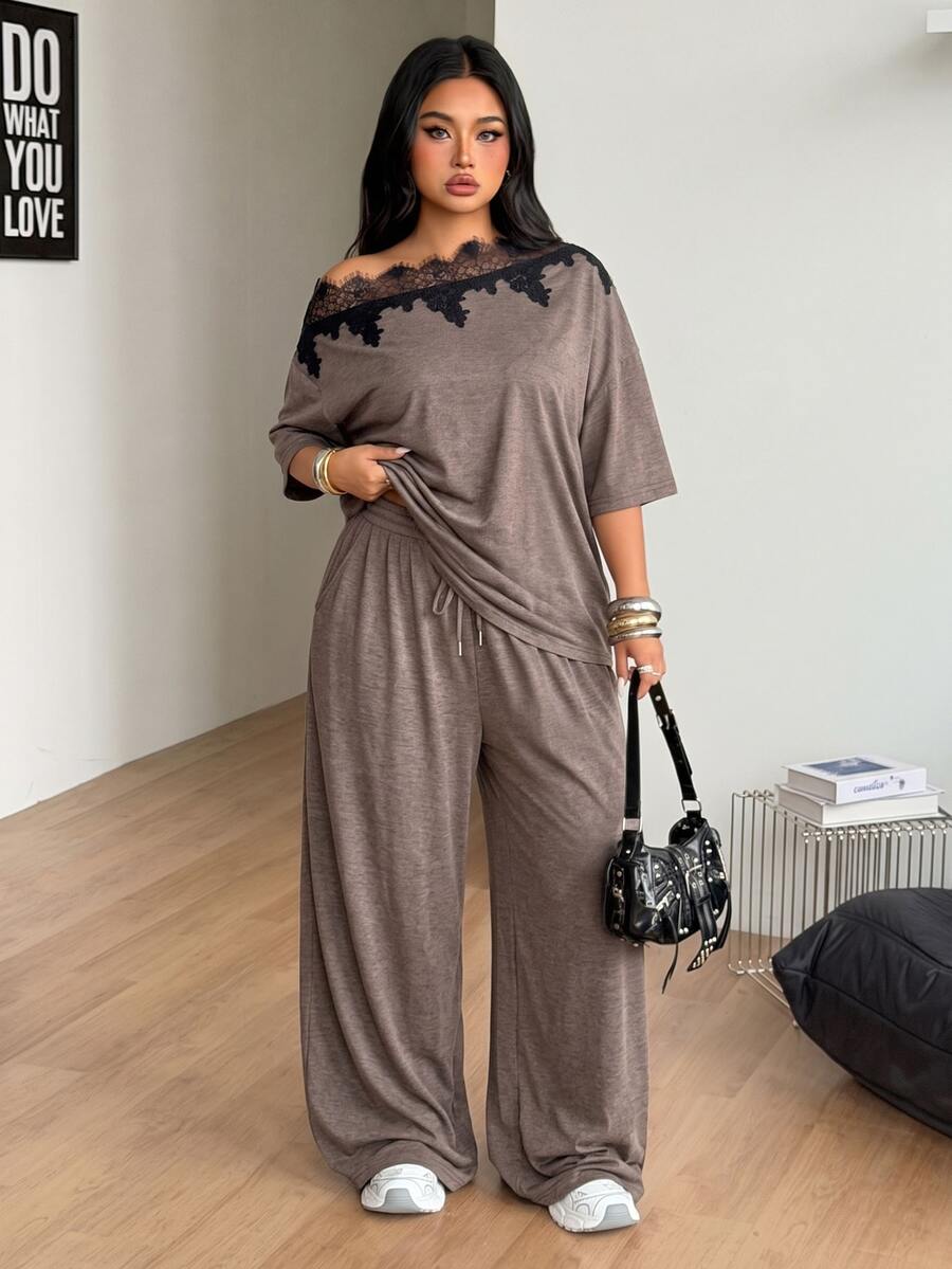 Women's casual two-piece outfit featuring a loose short-sleeve asymmetrical neck t-shirt and matching long wide leg pants with pockets.