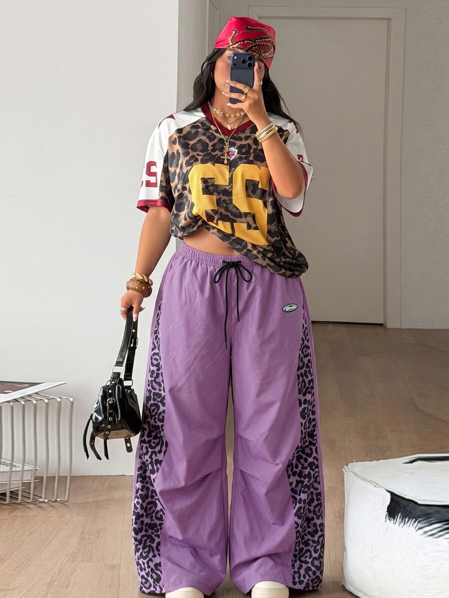 Women's high waist wide leg pants in black featuring leopard print patchwork details and an elastic drawstring waistband.