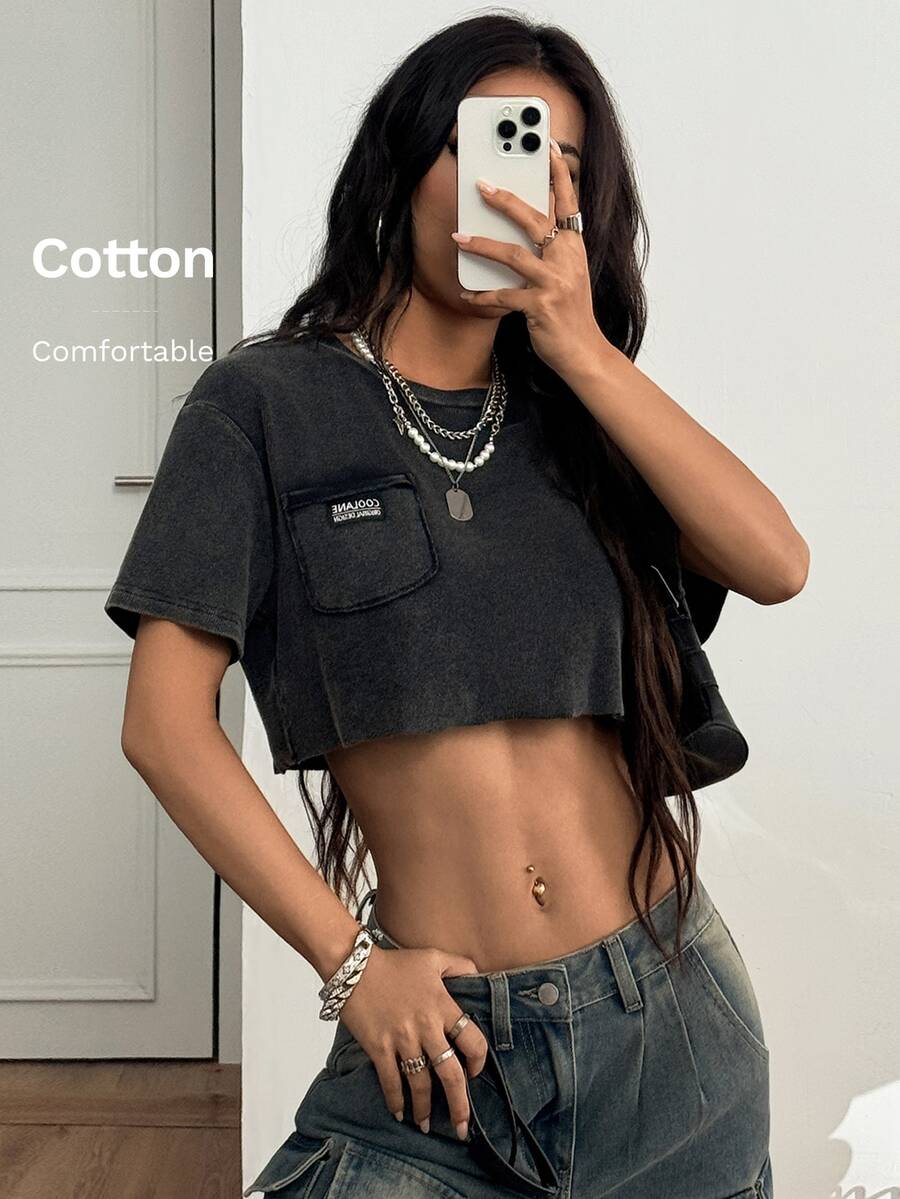 Women's short sleeve crop top with a round neckline and drop shoulder design in black knitted fabric.