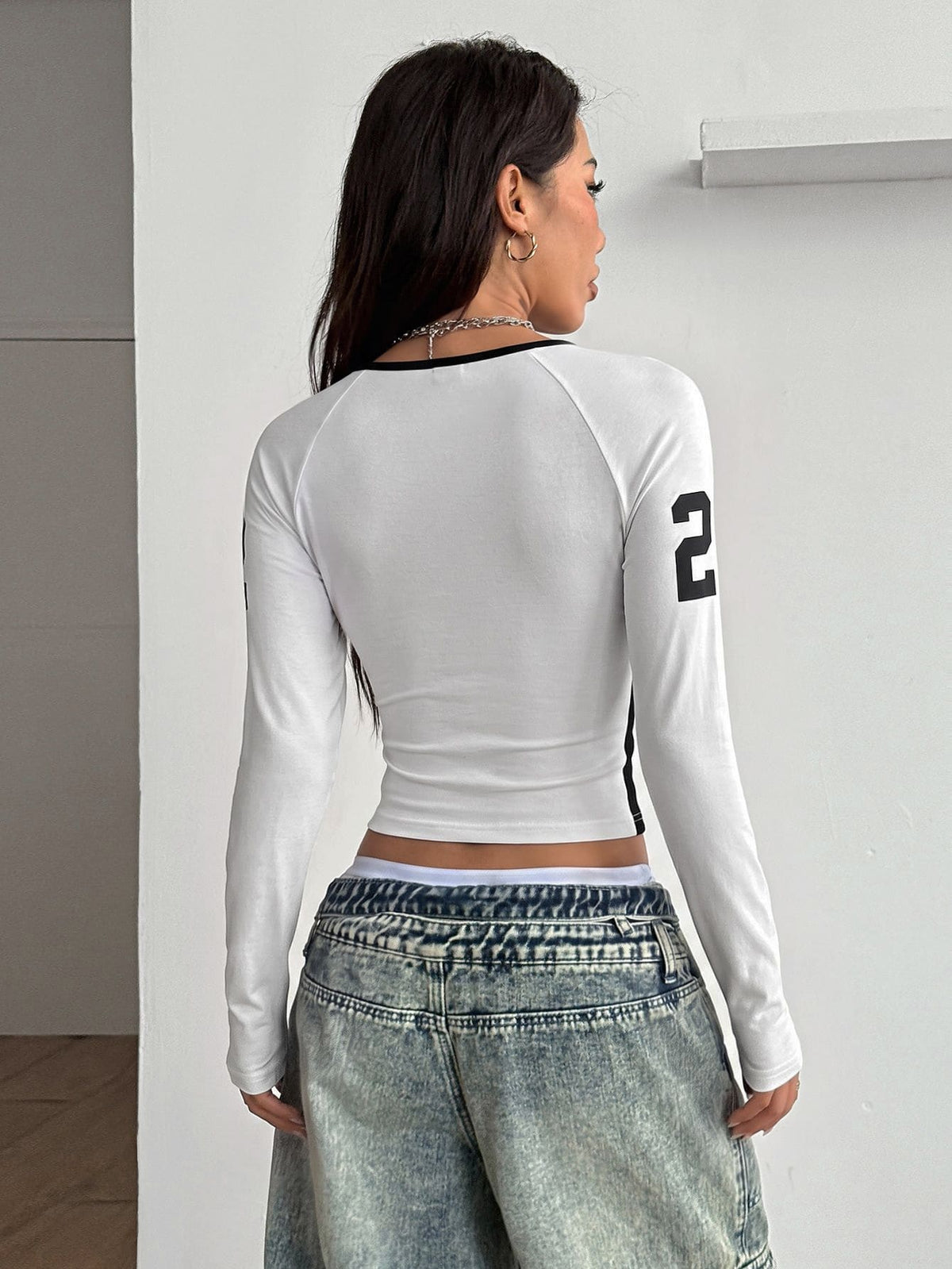 Women's slim fit long sleeve raglan t-shirt with collegiate letter graphic print, round neck, and contrast binding.