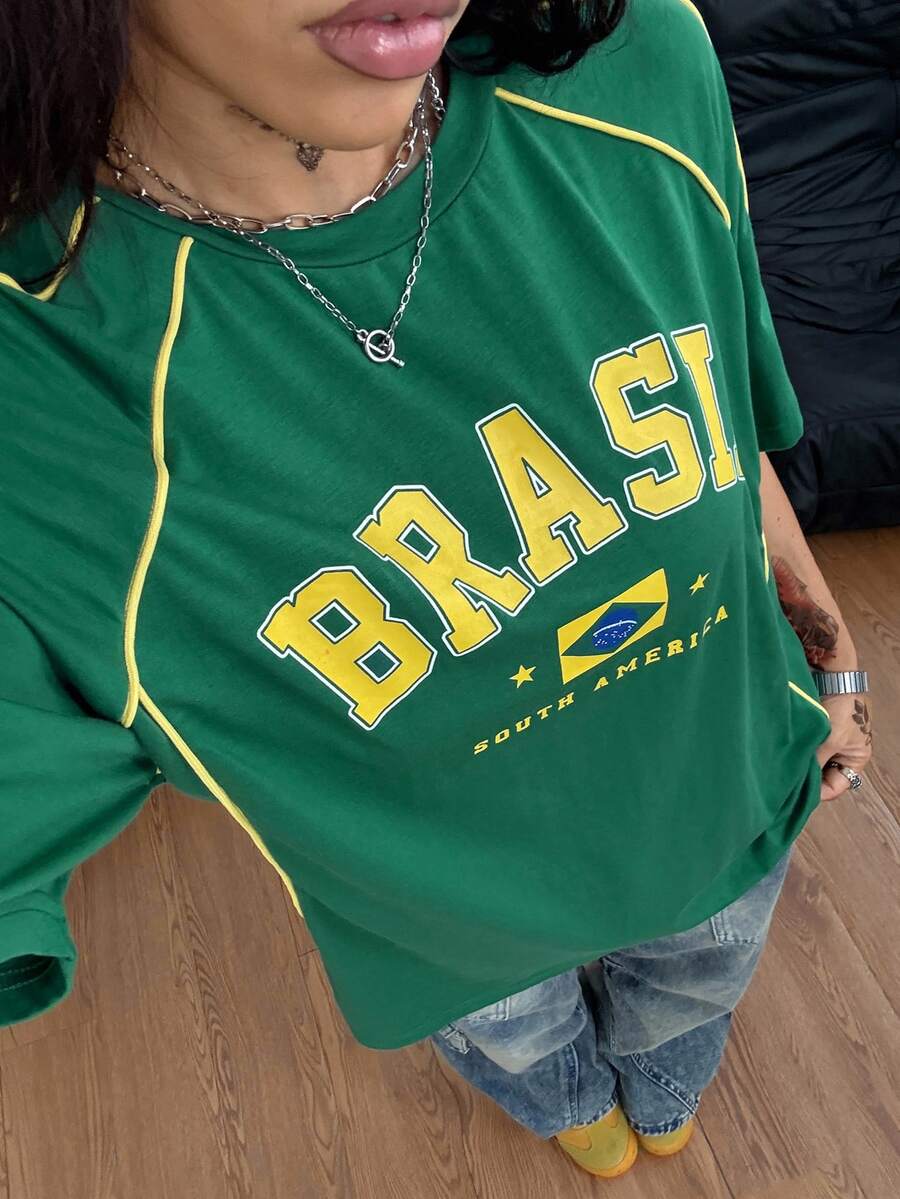 Yellow oversized graphic t-shirt featuring Brazil letter print on the front with contrast raglan sleeves and side stripe detailing.