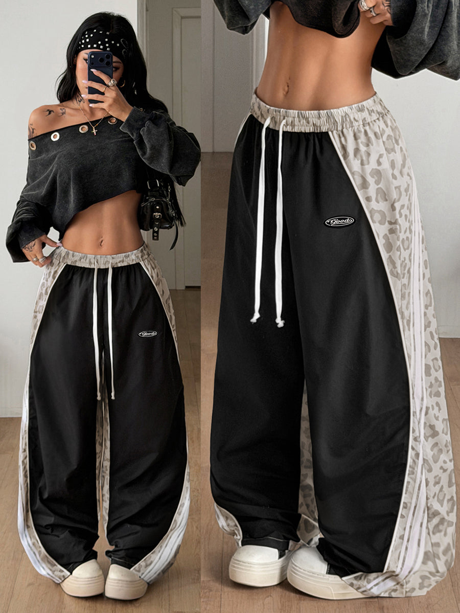 Women's loose fit straight leg pants in black and white with banded texture design, low drawstring waist, and pockets.