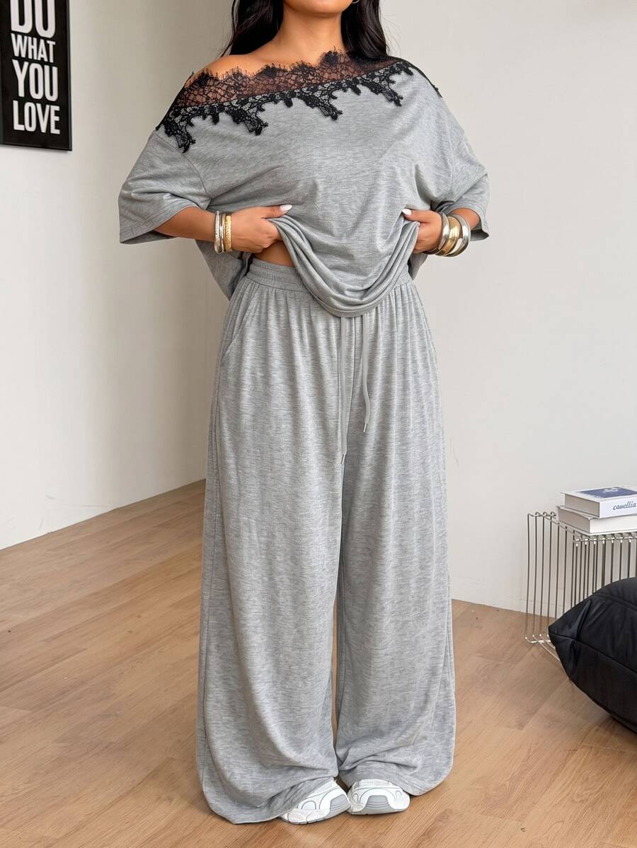Women's casual two-piece outfit featuring a loose short-sleeve asymmetrical neck t-shirt and matching long wide leg pants with pockets.