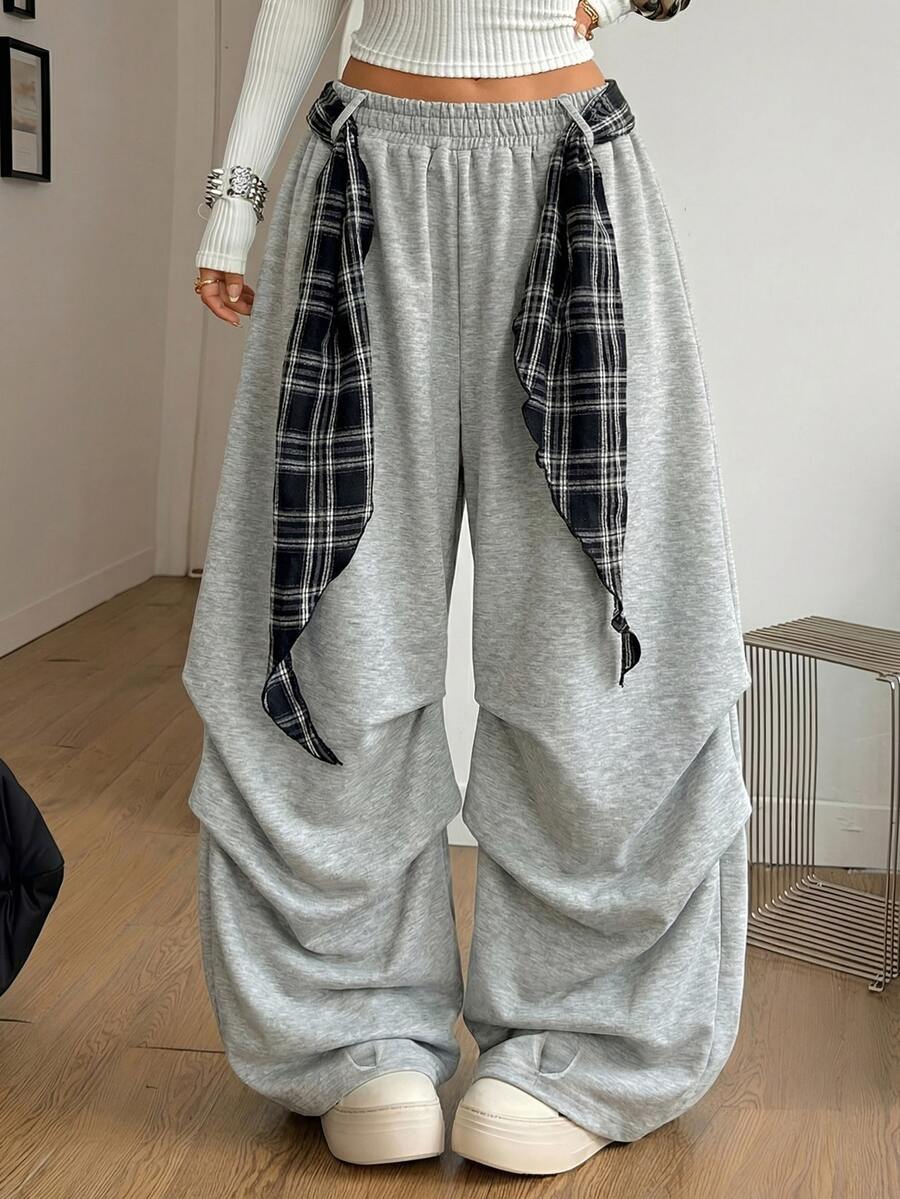 Loose-fitting black baggy parachute pants featuring an elastic drawstring waistband and wide-leg cut made from cotton blend fabric.