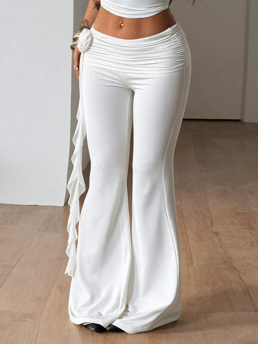 Black low waist flare pants featuring 3D rose and side stripe detailing in stretchy mesh fabric.