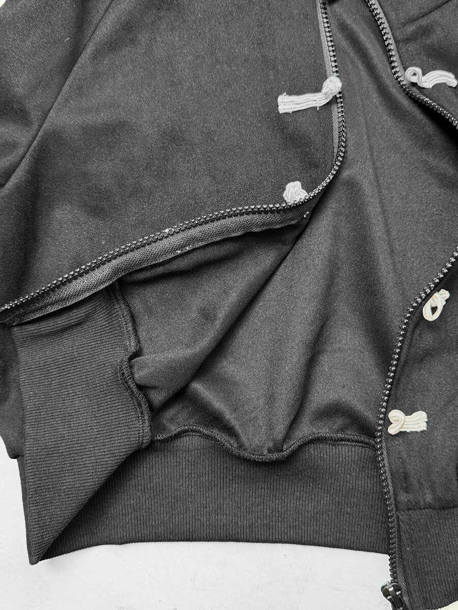 Women's black cropped track jacket with white colorblock tape details, stand collar, and front zip closure.