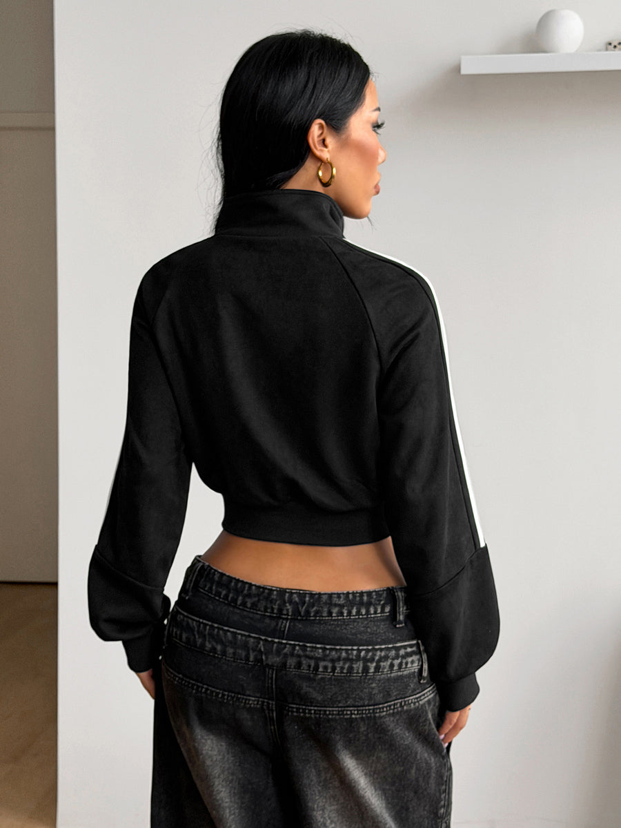 Women's black cropped track jacket with white colorblock tape details, stand collar, and front zip closure.