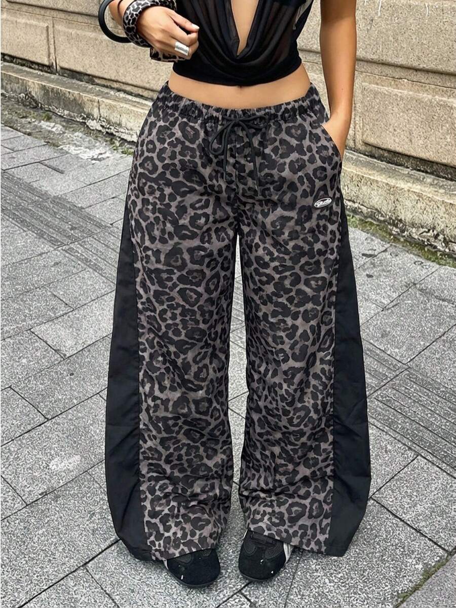 Women's black baggy jogger pants with an adjustable drawstring waist and colorblock polka dot geometric pattern.