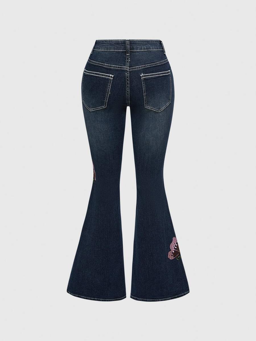 Women's blue ultra low waist flare jeans with butterfly vine embroidery and rhinestone detailing on stretch denim.