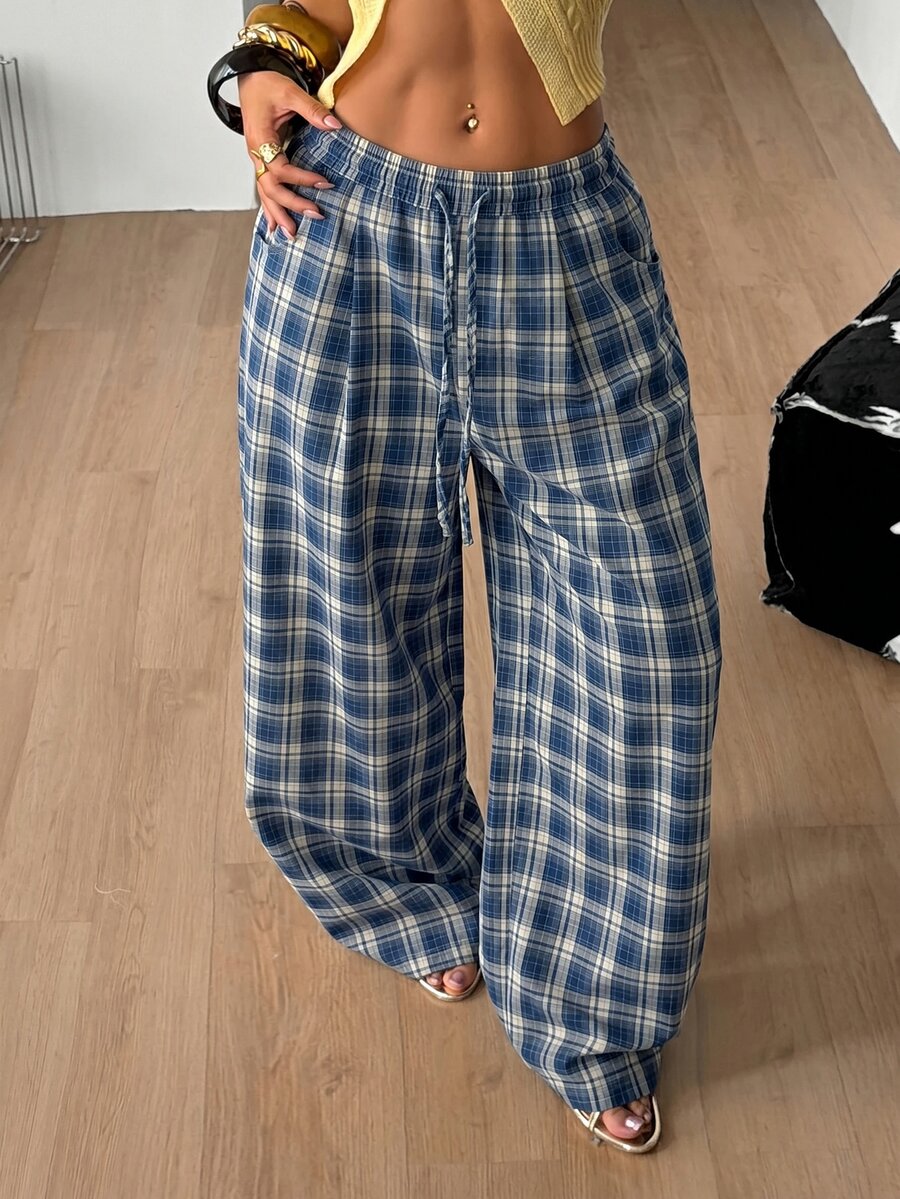 Women's loose fit brown and tan plaid wide leg pants featuring an elastic drawstring waist and side pockets.