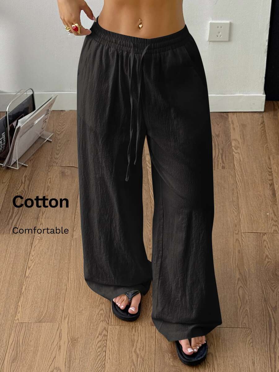 Women's loose straight leg cotton pants featuring a high waist with an adjustable drawstring knot and functional side pockets.