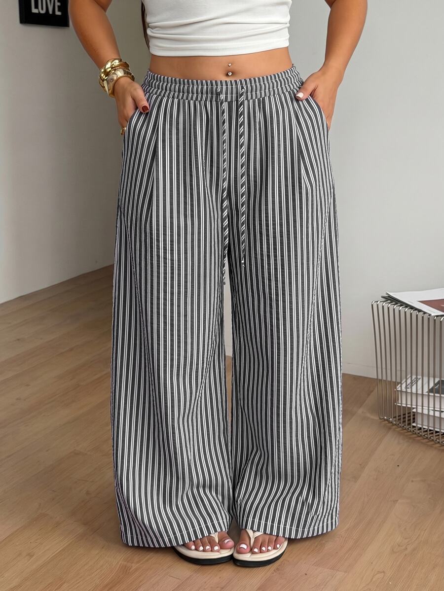 Plus size women's striped loose straight leg cropped pants with pleated detailing and side pockets