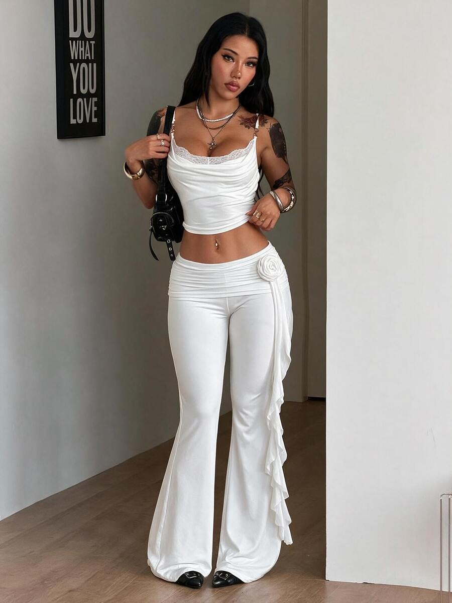Black low waist flare pants featuring 3D rose and side stripe detailing in stretchy mesh fabric.