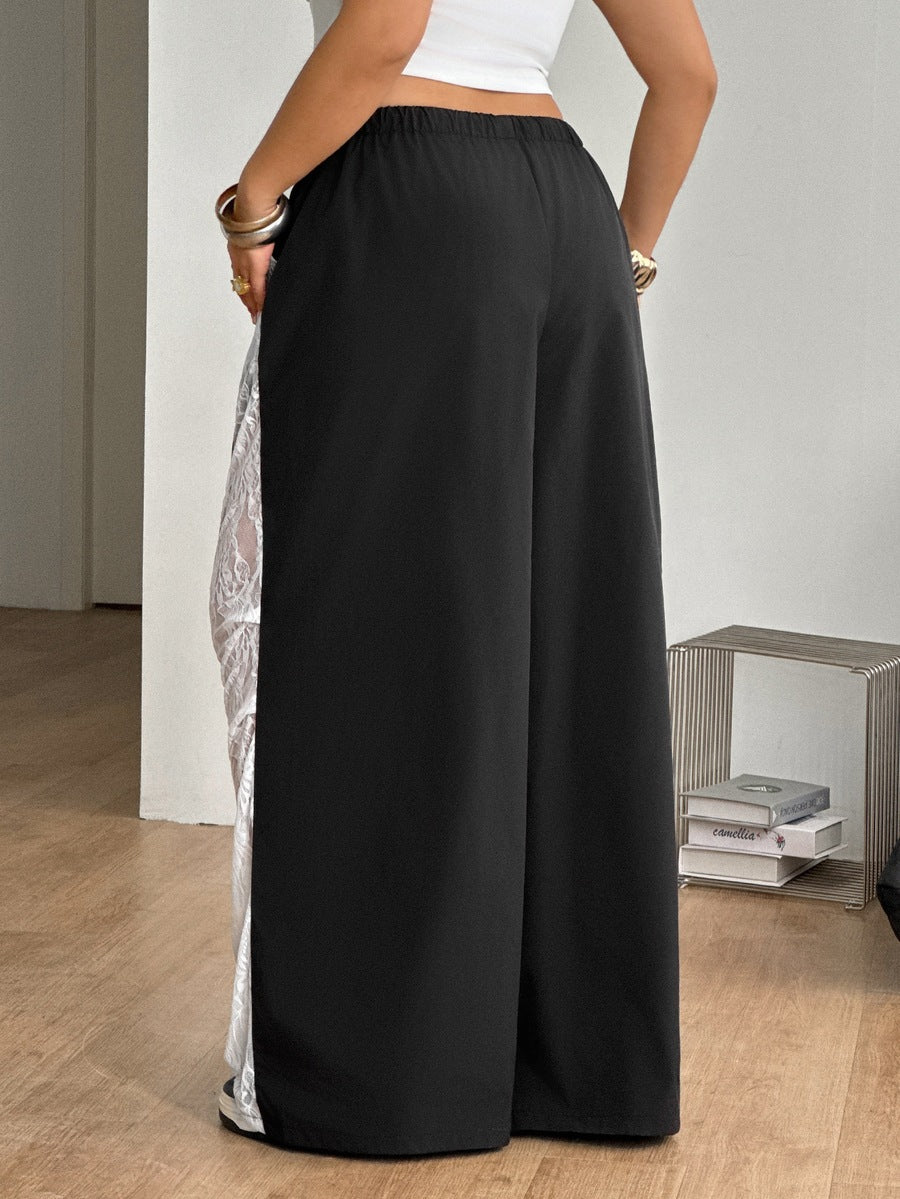Women's high waist wide leg pants in black featuring leopard print patchwork details and an elastic drawstring waistband.