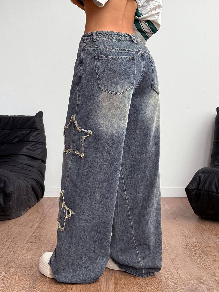 Women's loose fit baggy jeans in washed denim featuring star patches, slant pockets, and a mid-rise cut.