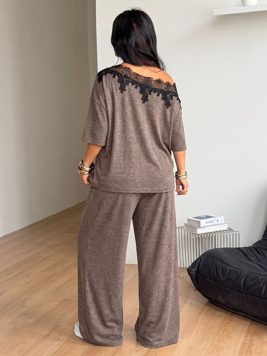Women's casual two-piece outfit featuring a loose short-sleeve asymmetrical neck t-shirt and matching long wide leg pants with pockets.