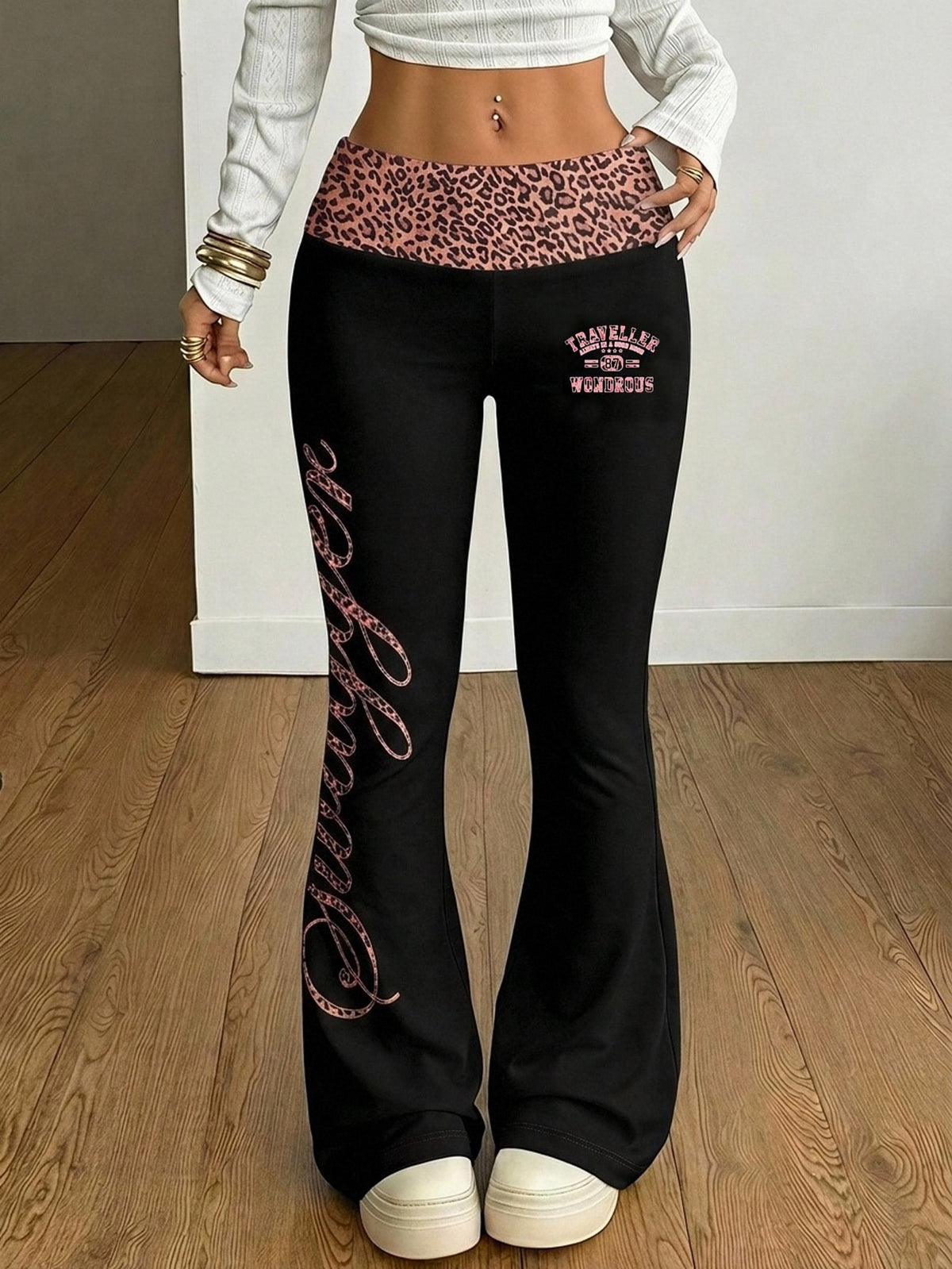 Women's black leopard print flare leg sweatpants with an elastic mid waist crafted from cotton knitted fabric.