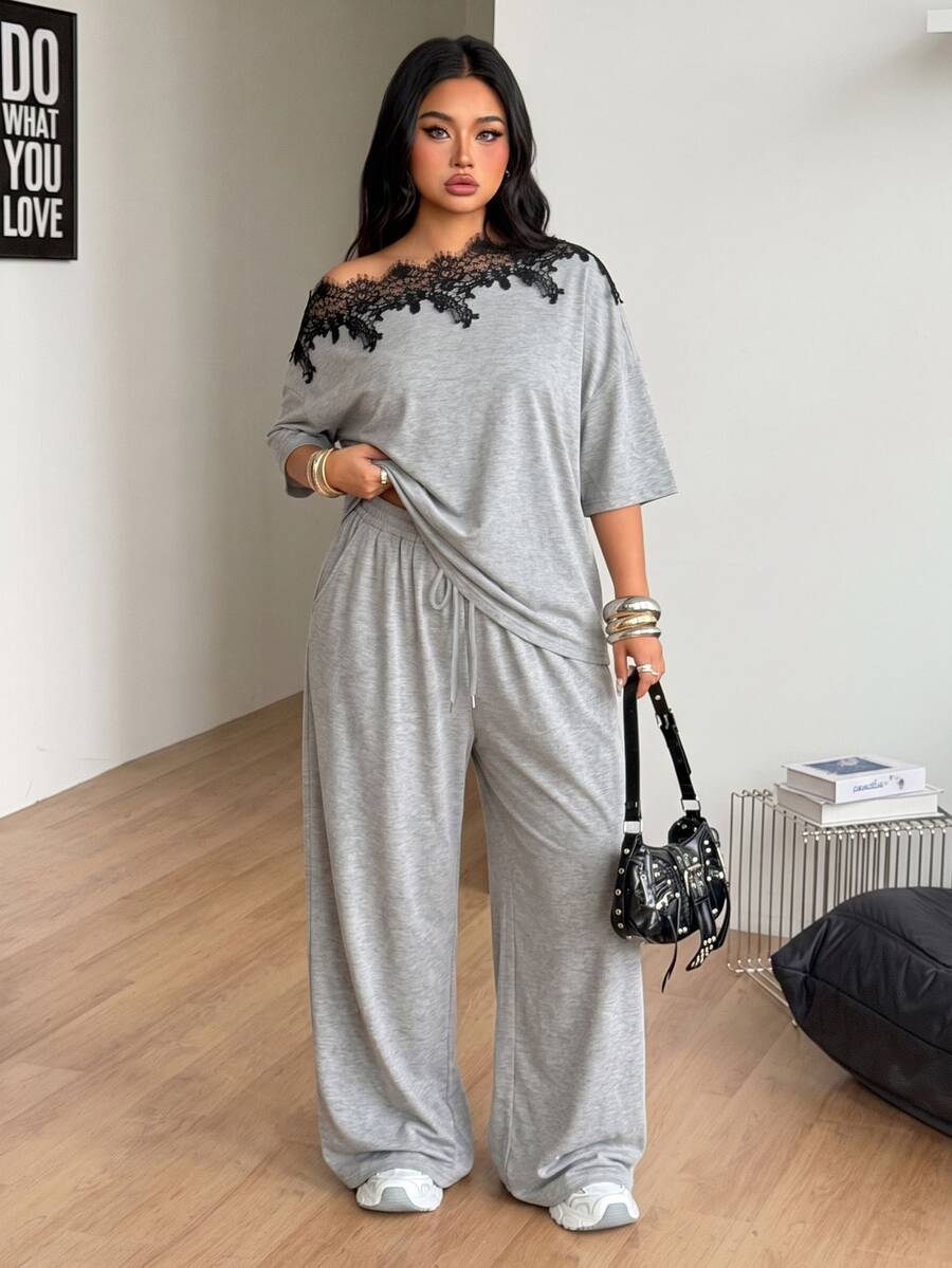 Women's casual two-piece outfit featuring a loose short-sleeve asymmetrical neck t-shirt and matching long wide leg pants with pockets.