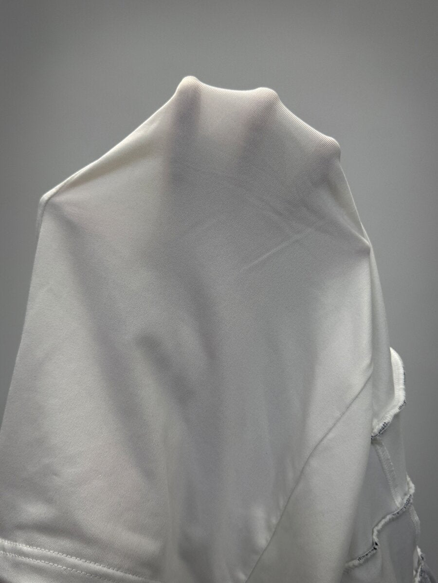 Women's white low waist tiered mini skirt featuring ruched detailing and a slight-stretch knitted fabric.