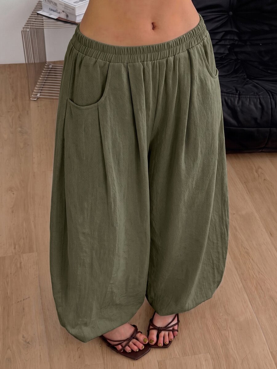 Women's loose-fit black bloomer pants made of 100% cotton featuring an elastic waistband and side pockets.