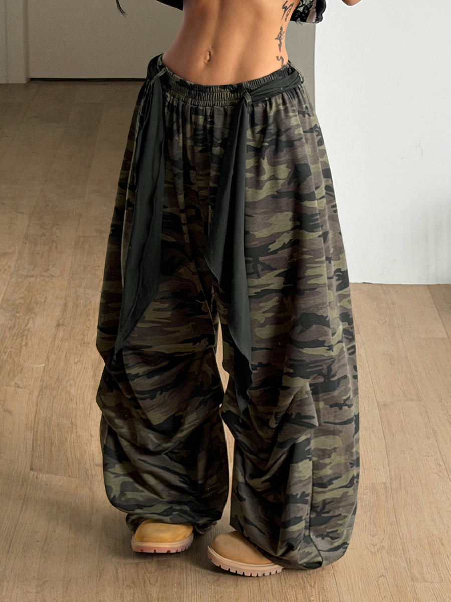 Loose-fitting black baggy parachute pants featuring an elastic drawstring waistband and wide-leg cut made from cotton blend fabric.