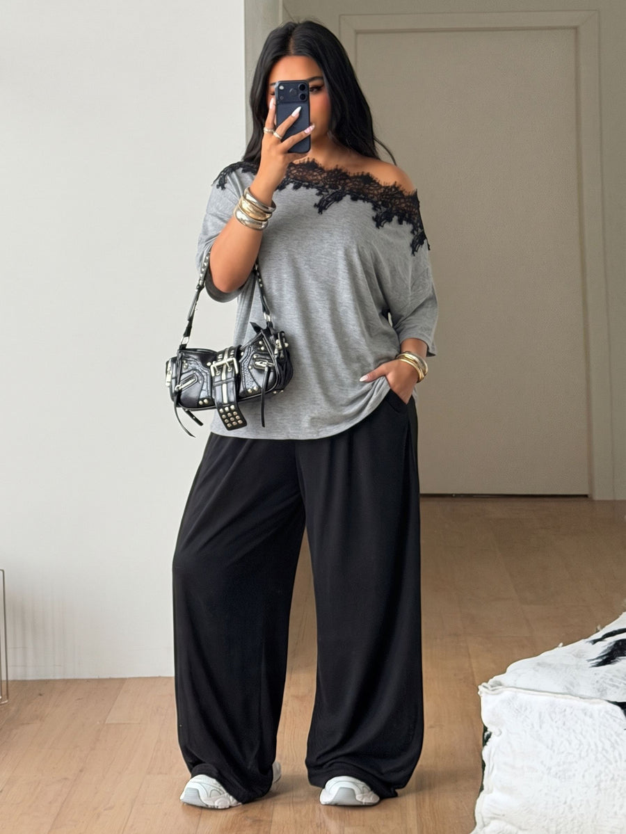 Women's casual two-piece outfit featuring a loose short-sleeve asymmetrical neck t-shirt and matching long wide leg pants with pockets.