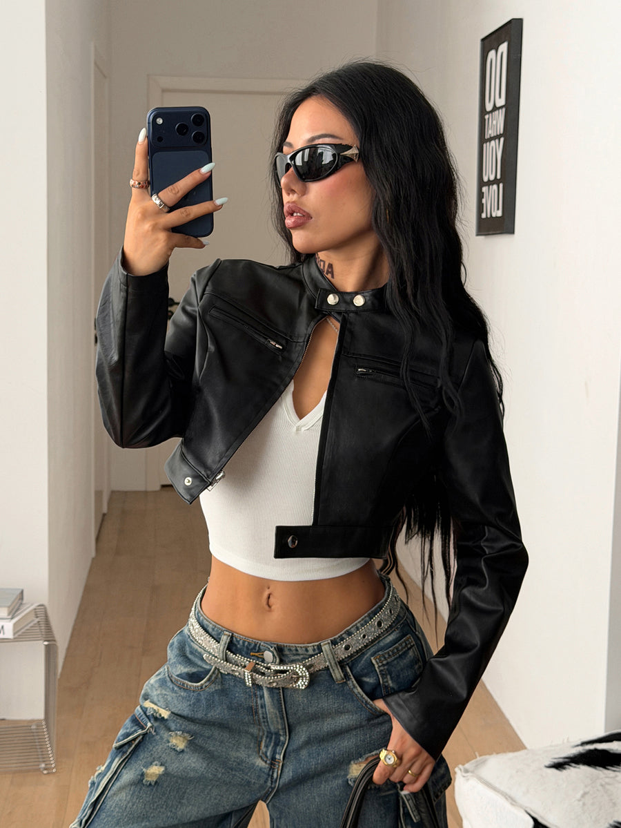 Front view of a women's black cropped PU leather jacket featuring a stand collar, long sleeves, and front zipper closure.
