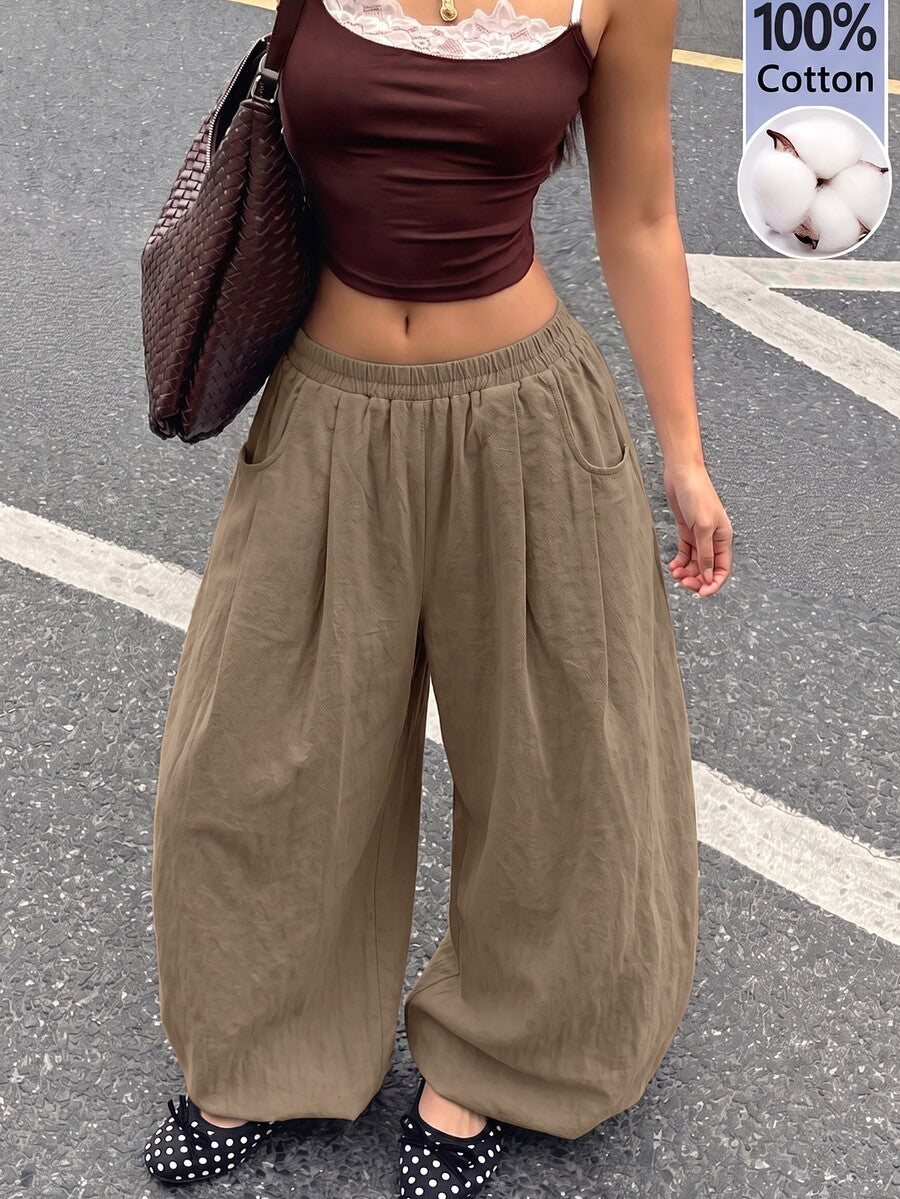 Women's loose-fit black bloomer pants made of 100% cotton featuring an elastic waistband and side pockets.
