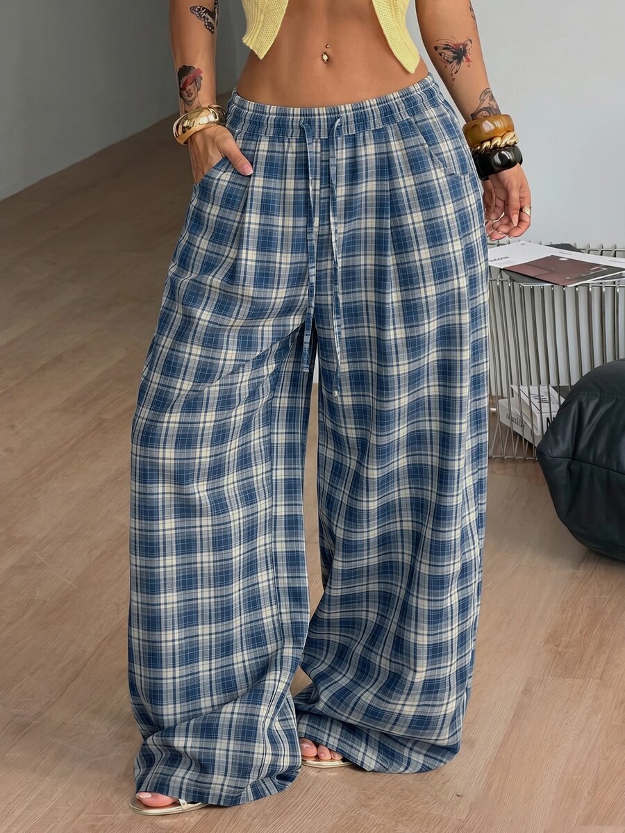 Women's loose fit brown and tan plaid wide leg pants featuring an elastic drawstring waist and side pockets.