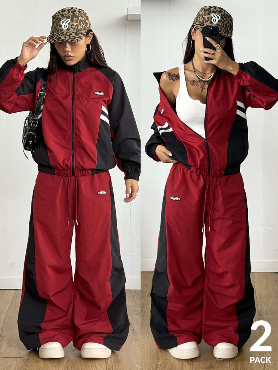 Women's plus size two-piece casual tracksuit set in black, featuring a loose-fit zip-up jacket with stand collar and matching cropped parachute pants.