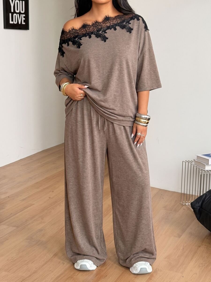 Women's casual two-piece outfit featuring a loose short-sleeve asymmetrical neck t-shirt and matching long wide leg pants with pockets.