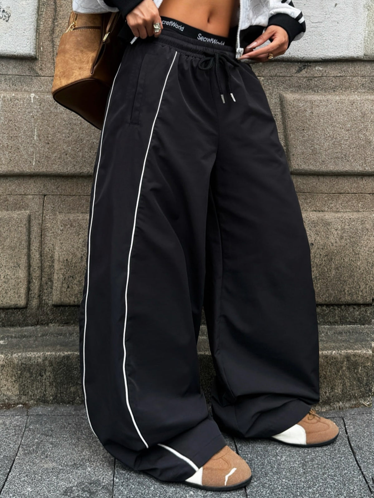 Women's loose fit straight leg pants in black and white with banded texture design, low drawstring waist, and pockets.