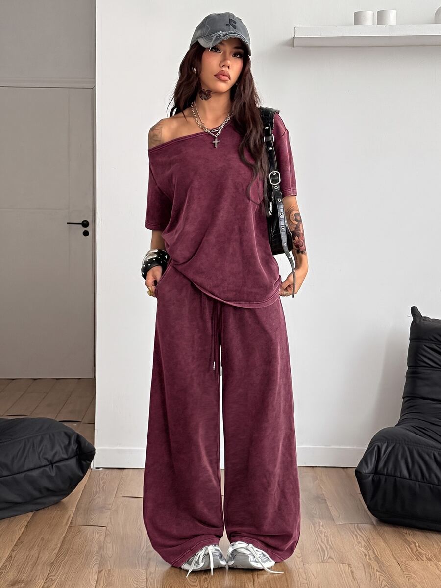 Women's two-piece outfit featuring an oversized asymmetrical neck t-shirt and matching wide-leg drawstring sweatpants.