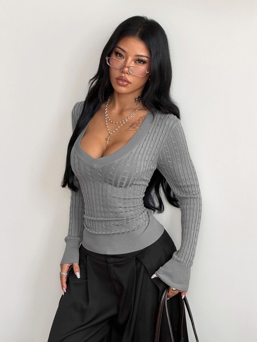 Women's slim fit cable-knit sweater with a V-neckline and long sleeves in solid green rib knit fabric.