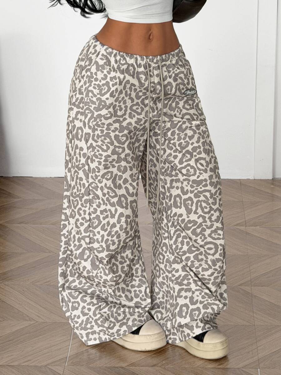 Women's black baggy jogger pants with an adjustable drawstring waist and colorblock polka dot geometric pattern.