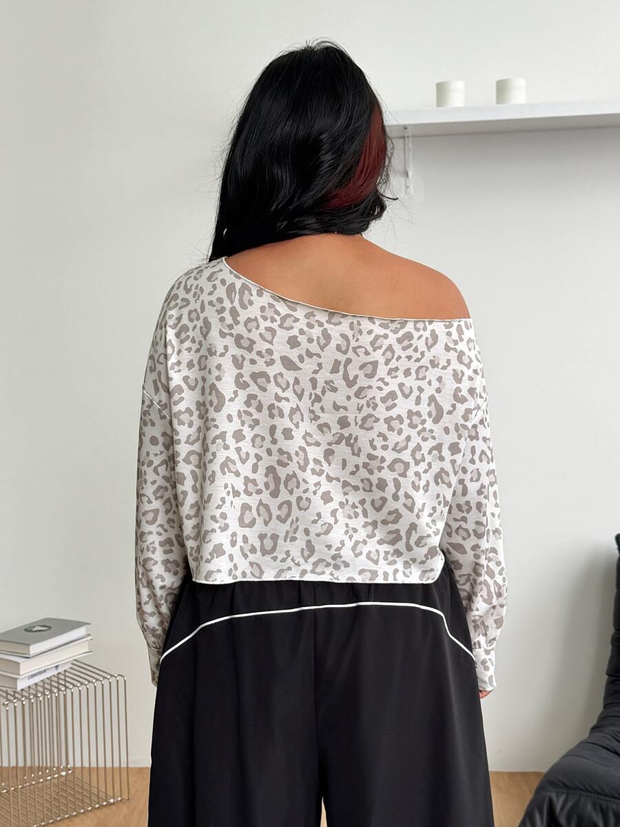 Plus size women's cropped leopard print sweatshirt featuring an asymmetrical neckline and long drop-shoulder sleeves.